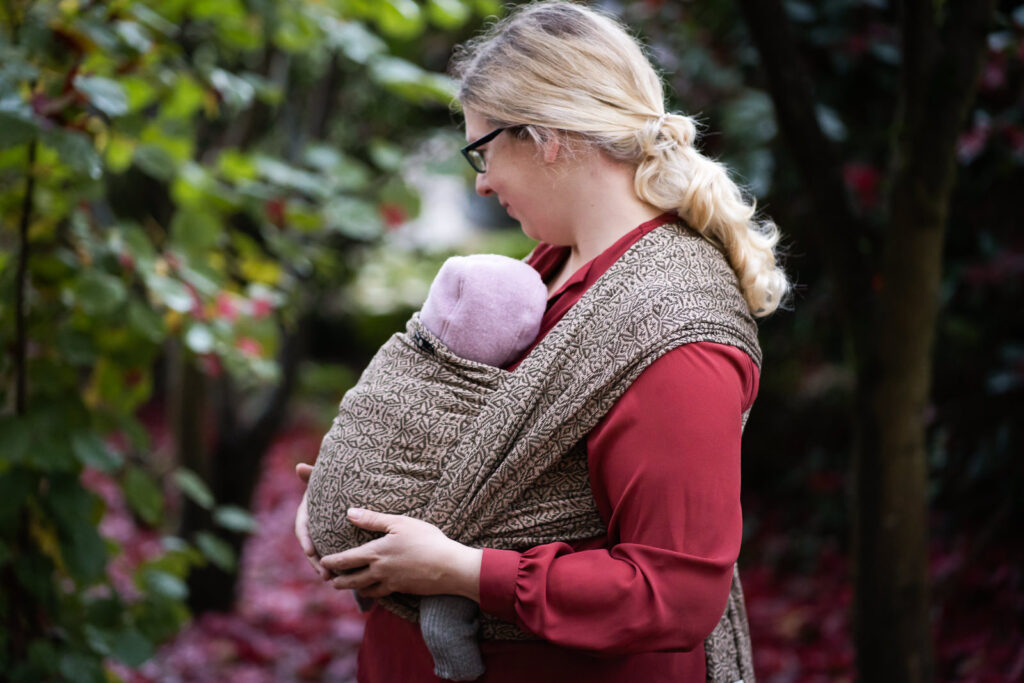 Baby mit gerundetem Rücken in Babytrage