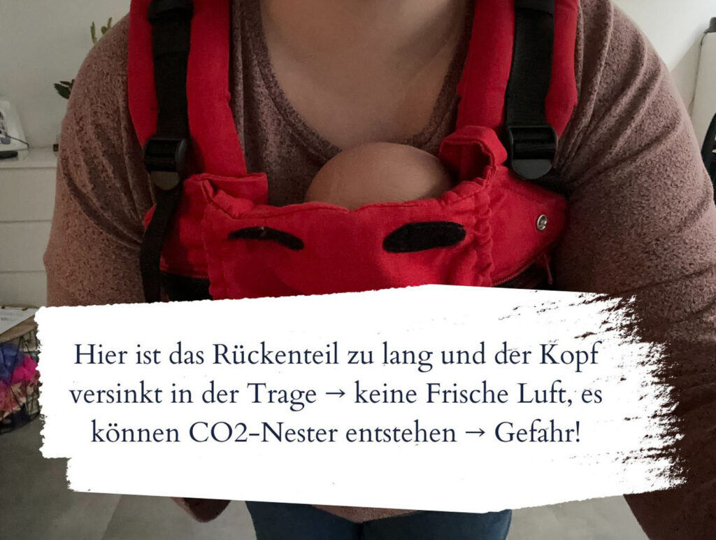 Falsch eingestellte Babytrage mit blockierter Atmung beim Baby. Trageberaterin weist auf Gefahr hin